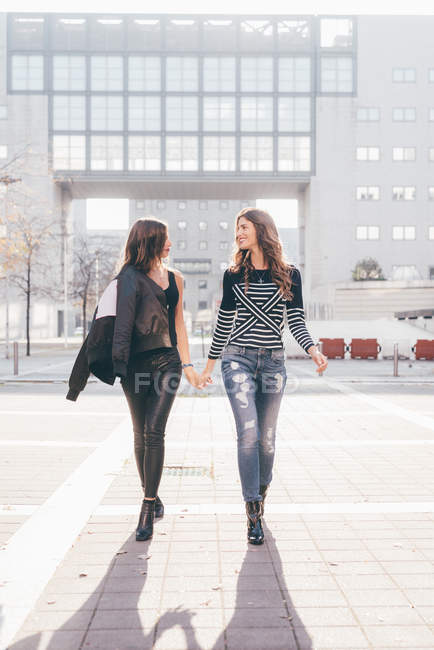 Irmãs gêmeas, andando ao ar livre, de mãos dadas — Fotografia de Stock
