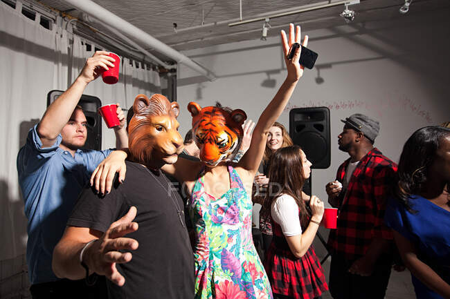 Menschen mit Löwen- und Tigermasken tanzen auf Party — Stockfoto
