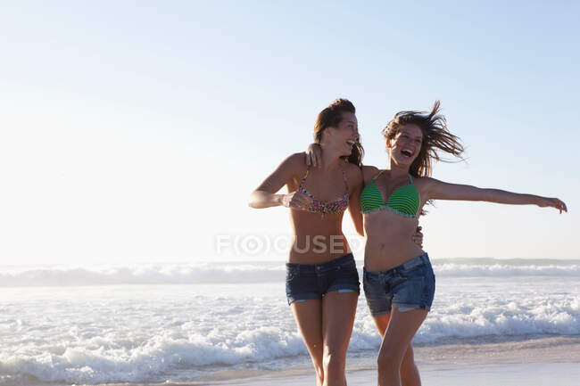 Две девушки бегут по пляжу — стоковое фото