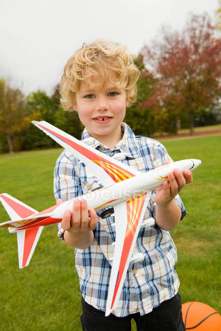 Menino brincando com avião de brinquedo ao ar livre — Fotografia de Stock