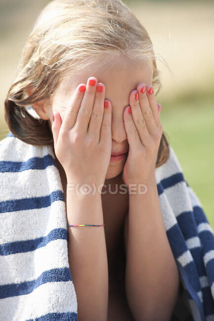 Menina envolto em toalha com as mãos sobre os olhos — Fotografia de Stock