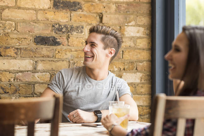 Giovane coppia ridere e parlare nel bar — Foto stock