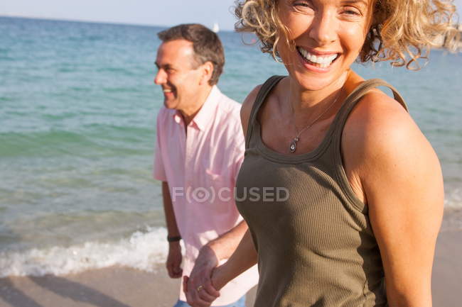 Счастливая зрелая пара прогуливаясь рука об руку на пляже, Майорка, Испания — стоковое фото