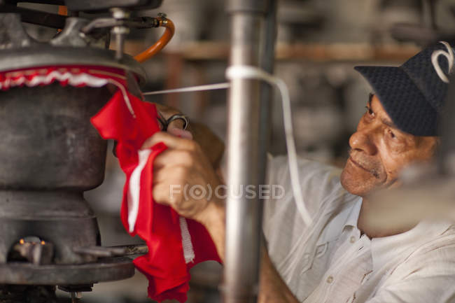 Hat maker cutting and stretching fabric in workshop — Stock Photo