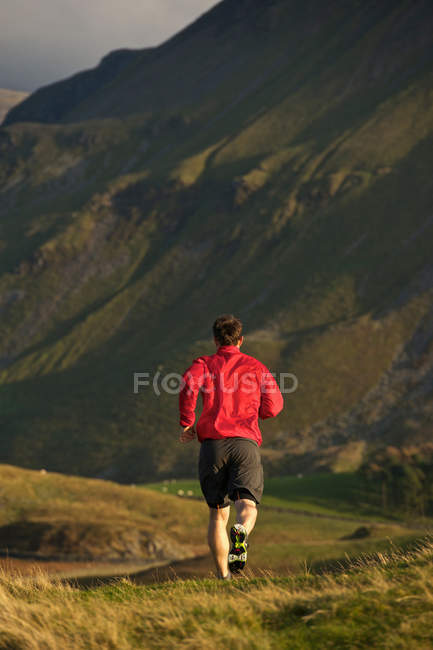 Homme courant sur la route de montagne rurale — Photo de stock