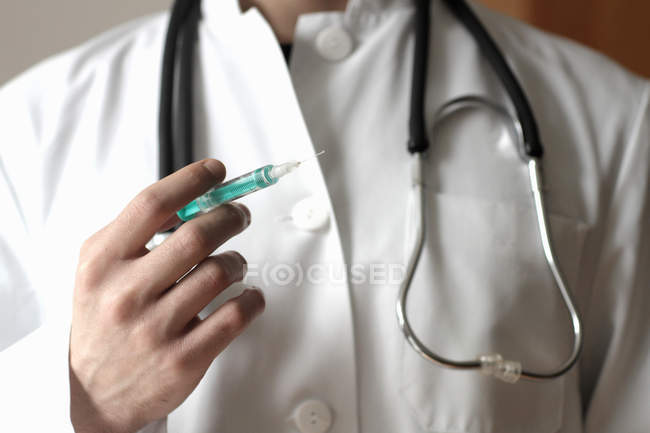 Cropped image of Doctor holding syringe — Stock Photo