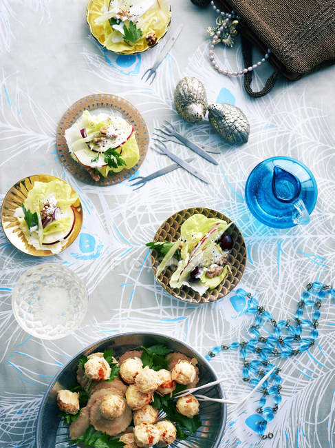 Верхний вид на ретро стол с тарелками сырных шариков и салатом Уолдорф — стоковое фото