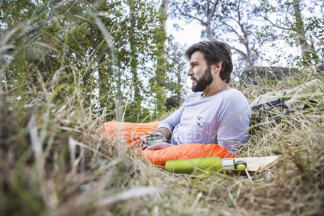 Man gazing from sleeping bag in forest, Deer Park, Cape Town, South Africa — Stock Photo