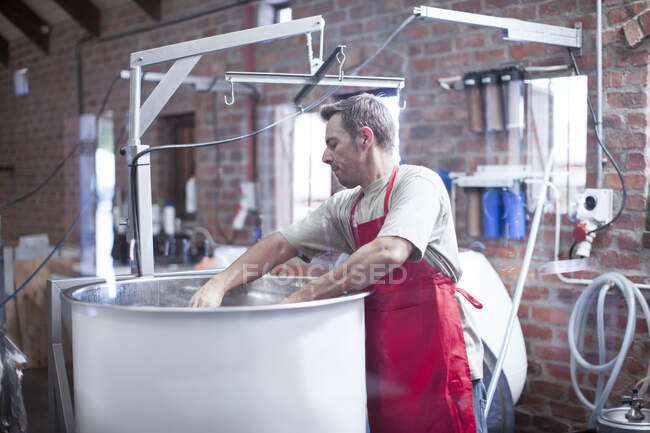 Cape Town, South Africa, male stirring from the cansiter in brewery room — Stock Photo