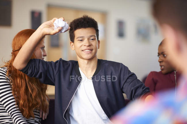 Estudiantes masculinos tirando papel arrugado en sala común - foto de stock