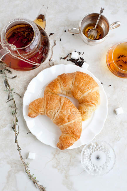 Croissants, honey and tea on table — Stock Photo