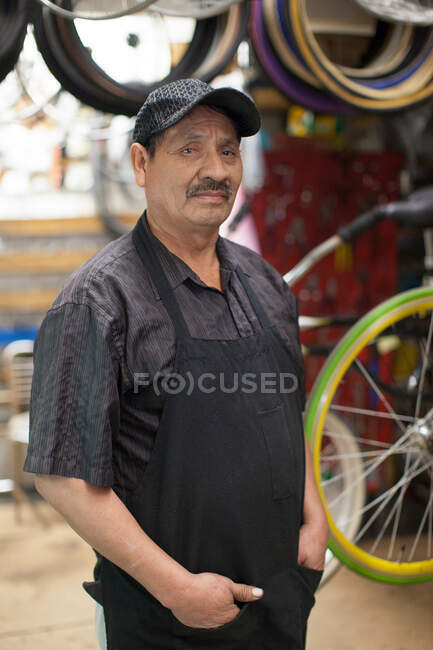 Механик, стоящий в магазине велосипедов — стоковое фото