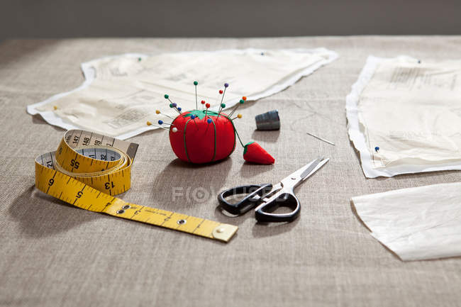Patrón de costura, cojín pin y cinta adhesiva en la mesa - foto de stock