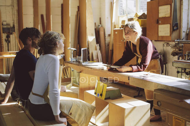 Três trabalhadores artesanais tendo uma reunião informal em oficina de órgão de tubulação — Fotografia de Stock