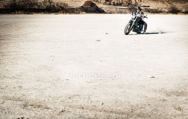 Uomo maturo in moto su arida pianura, Cagliari, Sardegna, Italia — Foto stock