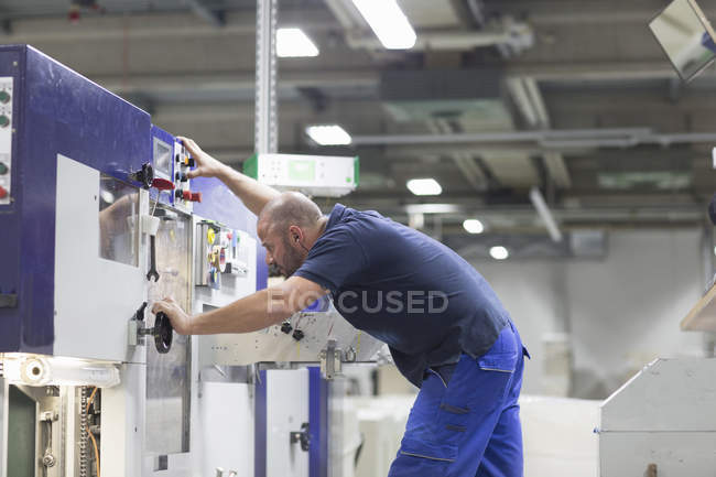 Worker using machine in paper packaging factory — Stock Photo
