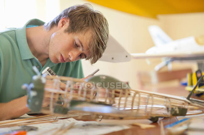 Человек, работающий над моделью самолета — стоковое фото