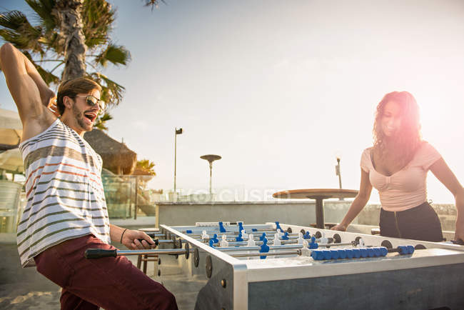 Young couple playing table football at San Diego beach — Stock Photo