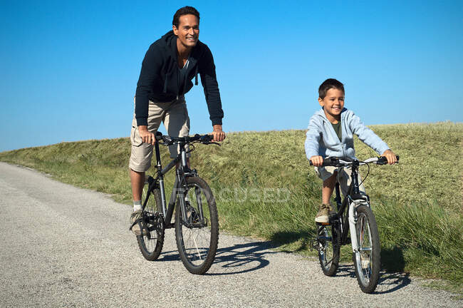 Отец и сын на велосипеде — стоковое фото
