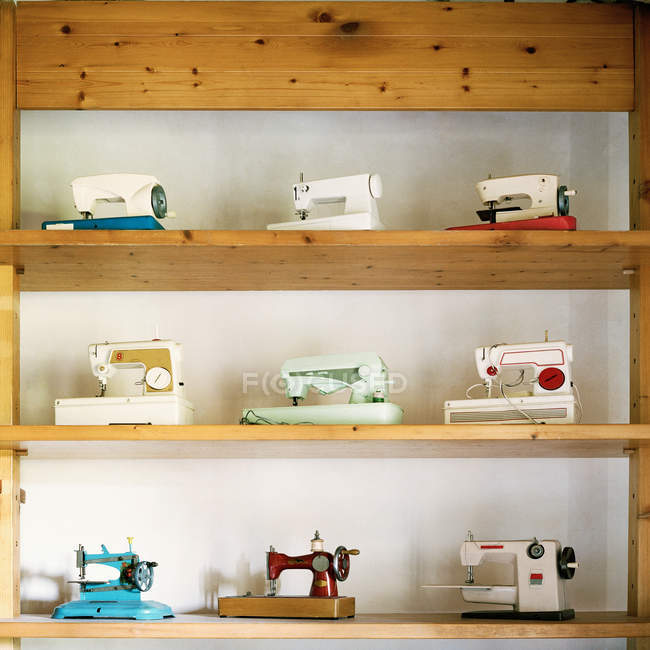 Збірка вінтажних швейних машин на полицях — стокове фото