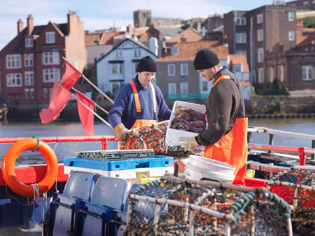 Fishermen with crabs and lobster pots — Stock Photo