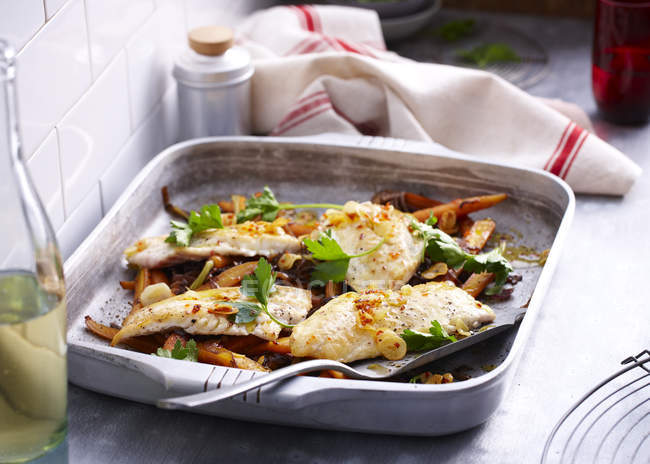 Baking tin with roasted fish fillet and herb garnish — Stock Photo