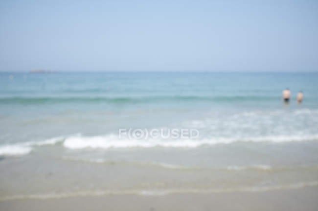 Dos personas de pie en el mar, tiro desenfocado - foto de stock