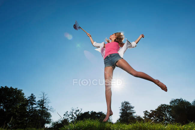 Woman using butterfly net outdoors — Stock Photo
