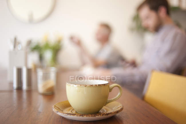 Кубок на столе и люди на заднем плане в кафе — стоковое фото