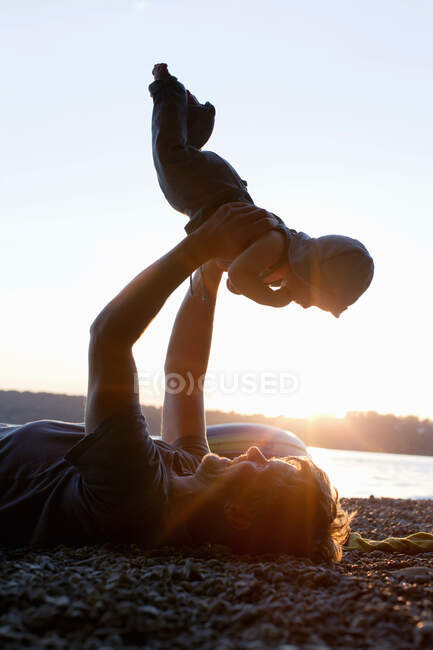 Pai levantando bebê filha — Fotografia de Stock
