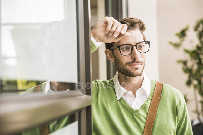 Cool businessman leaning against office doorway — Stock Photo