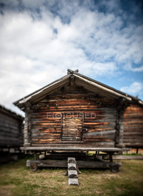 Cabaña de madera tradicional bajo cielo azul nublado - foto de stock