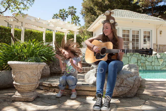 Menina com irmã mais velha tocando guitarra — Fotografia de Stock
