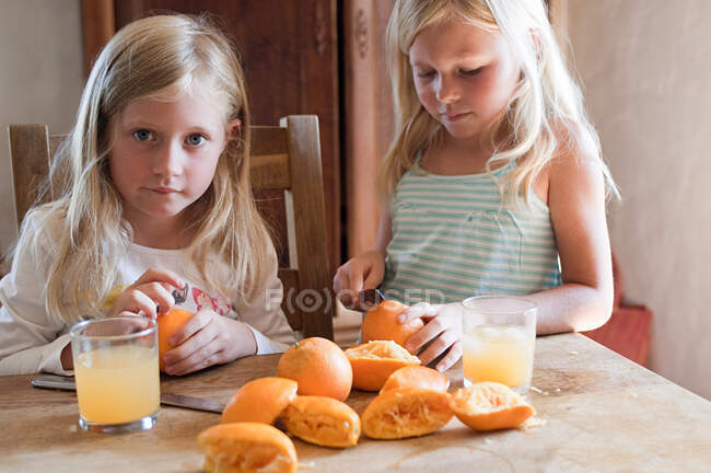Девушки делают свежий апельсиновый сок — стоковое фото