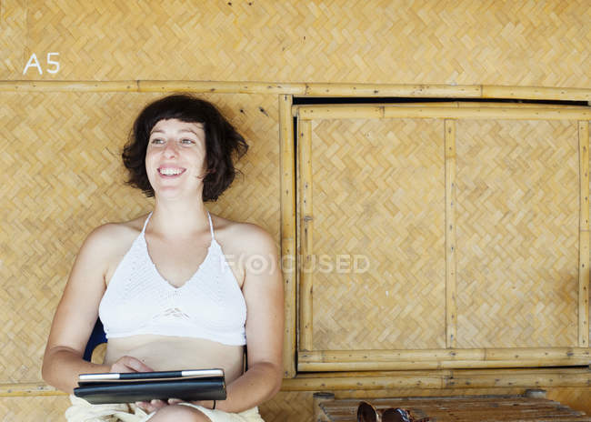 Femme utilisant une tablette numérique devant une cabane de plage, Kradan, Thaïlande — Photo de stock