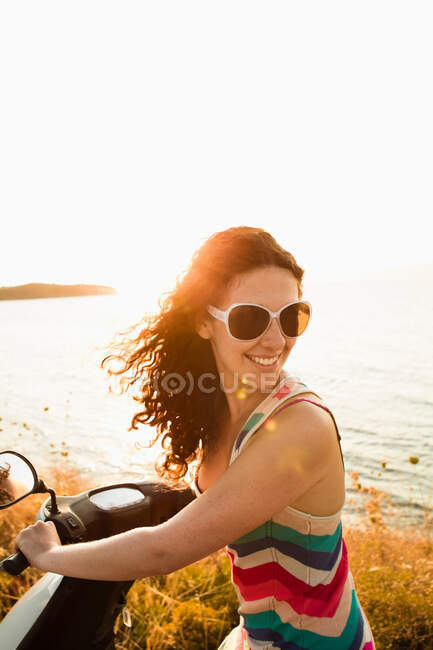Mujeres sonrientes montando scooter - foto de stock