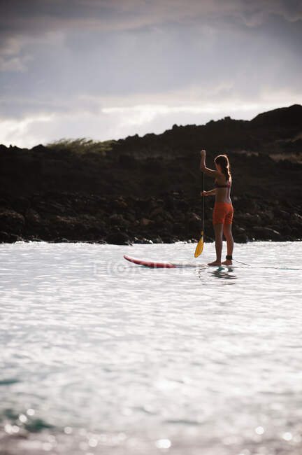 Surfista remando tabla de surf en el océano - foto de stock