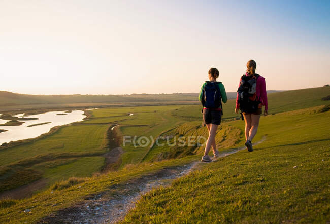 Escursionisti camminano verso il tramonto — Foto stock