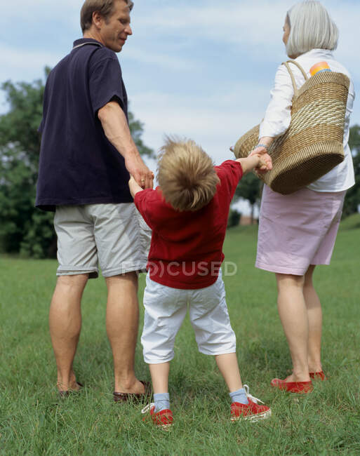 Niño y padres afuera. - foto de stock