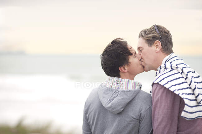 Homosexuell pärchen küssen auf strand — Stockfoto