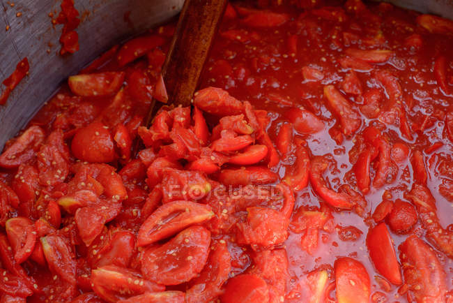 Primer plano tiro de tomates picados cocinar en la sartén - foto de stock