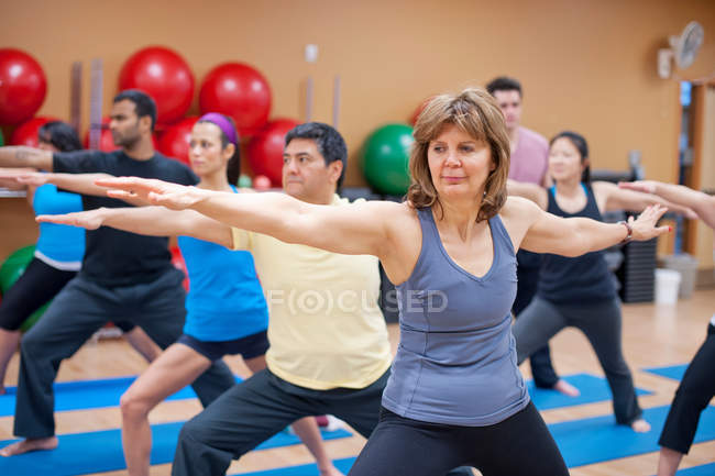 People practicing yoga in studio — Stock Photo
