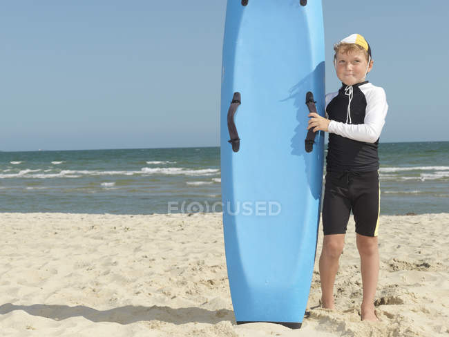 Портрет мальчика-ниппера (спасателя детей-серферов) рядом с доской для серфинга, Мона, Мельбурн, Австралия — стоковое фото