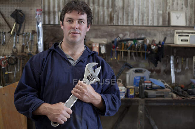 Retrato del hombre maduro sosteniendo la llave en el taller del barco — Stock Photo