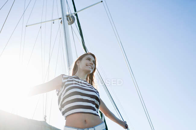 Giovane donna su yacht indossando top a righe — Foto stock
