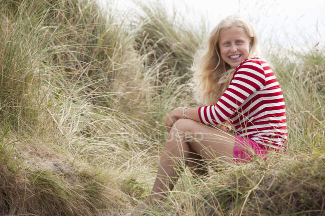 Retrato de adolescente sentada em dunas, País de Gales, Reino Unido — Fotografia de Stock