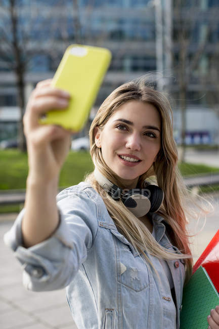 Jeune femme en plein air prenant selfie avec smartphone — Photo de stock
