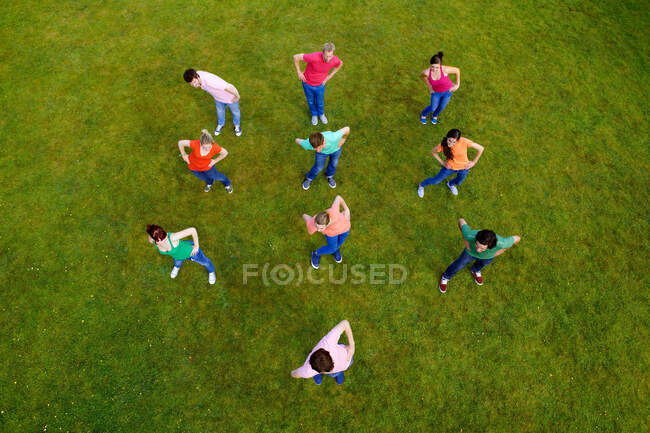 Les gens qui s'étirent ensemble dans l'herbe — Photo de stock