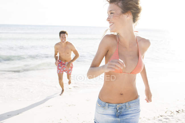 Homem correndo e perseguindo namorada na praia, Maiorca, Espanha — Fotografia de Stock