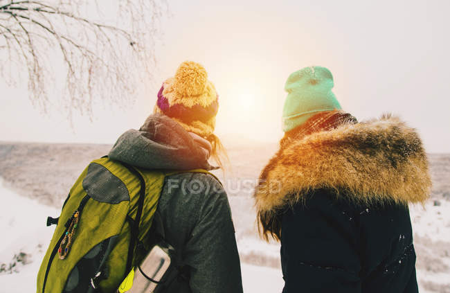 Vista posteriore della coppia che indossa cappelli a maglia guardando lontano alla vista — Foto stock